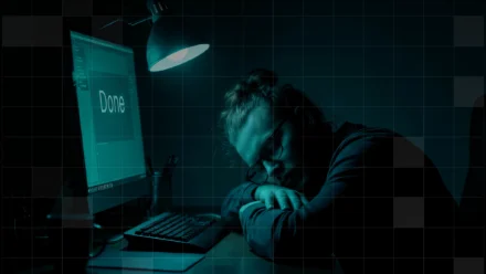 An IT admin sleeps on his desk in front of computer screen that says “Done”