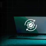 A Mac computer with a white gear checkmark icon - it’s updating itself.