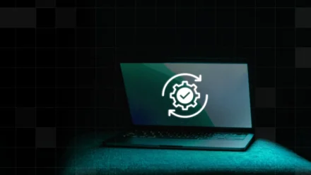 A Mac computer with a white gear checkmark icon - it’s updating itself.