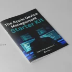 Mockup of Addigy's Apple Device Management Starter Kit guide, featuring a dark cover with a silhouette of a person in front of multiple monitors and the tagline "Apple that works for IT," alongside a small illustration of a person looking through binoculars toward the guide.
