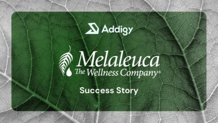 Addigy and Melaleuca: The Wellness Company Success Story graphic, featuring both logos over a close-up of a green leaf with visible veins against a grey leafy background.