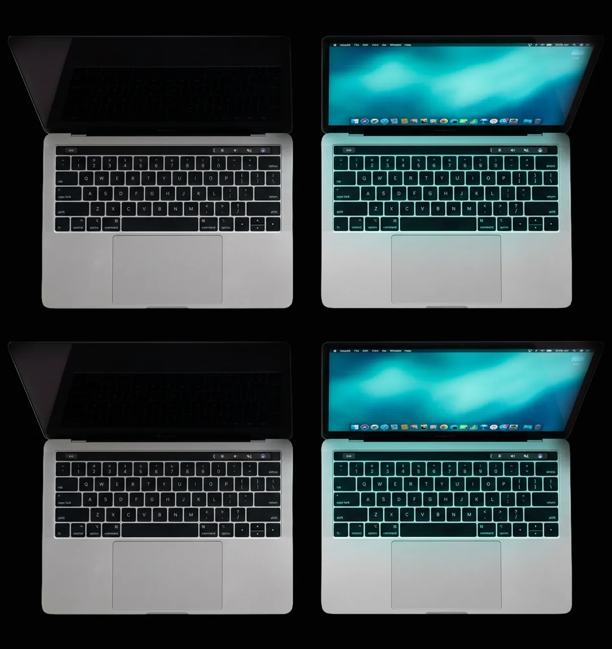 MacBook Pros side by side, two with a dark off screen and two glowing with soft teal light, top-down view on a dark surface