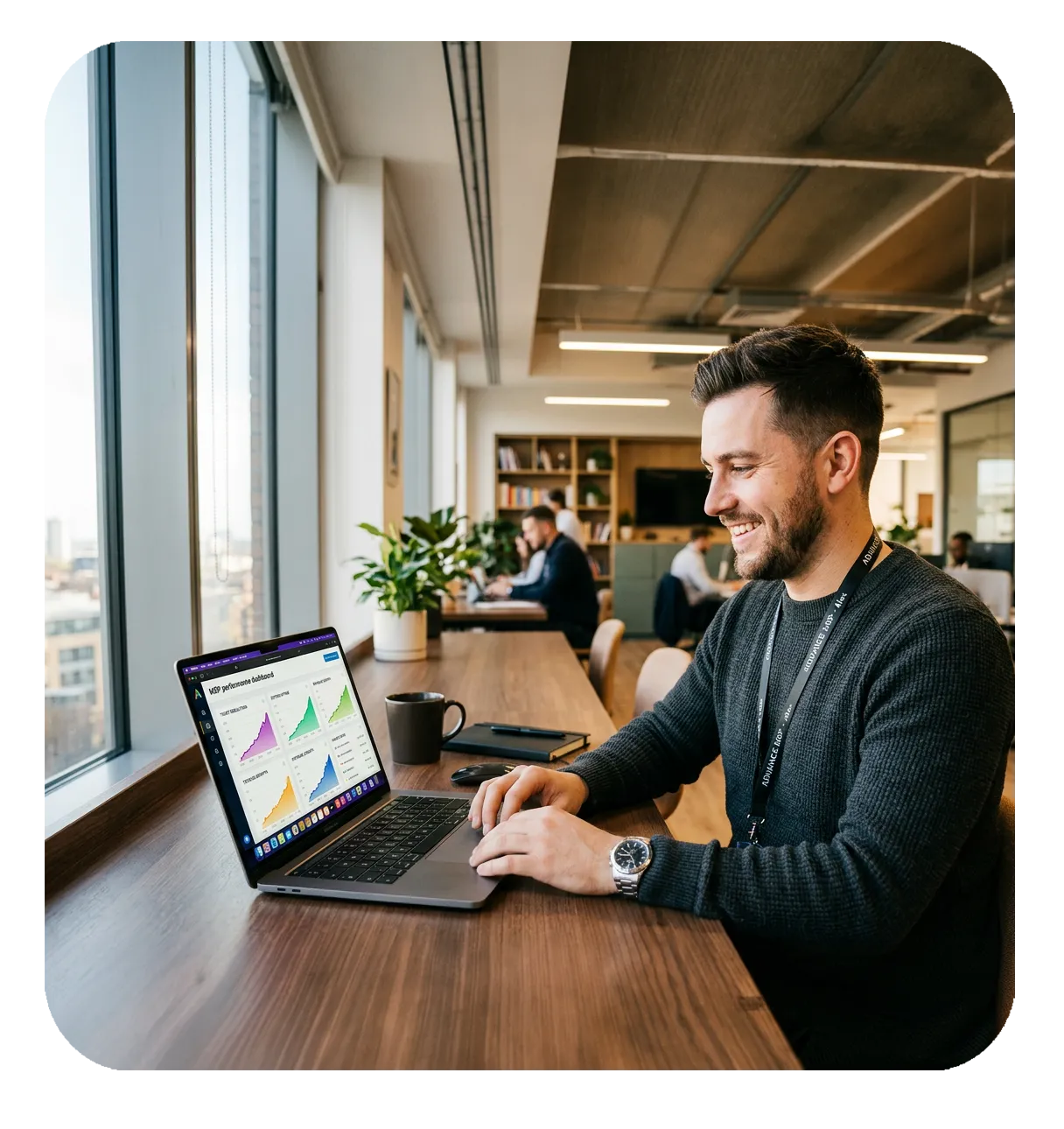 Confident IT professional smiling while reviewing an upward trending dashboard on a MacBook Pro in a modern bright office